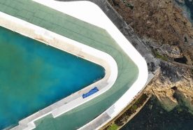 A concrete pool sticks into the sea, seen from above