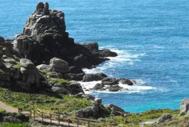 Rocky outcrop in blue sea in Cornwall