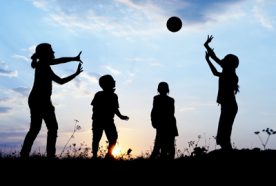 Silhouette of 4 children throwing a ball