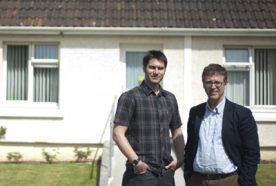 Nick Osborne and Richard Sharpe posing outside a house