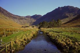 A small stream runs toward a mountainous landscape