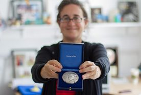 Lora Fleming holds out her Bruun medal to the camera