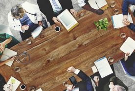 A top-down view of medical professionals talking around a table