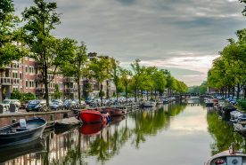 Boats and houses line a canal in Amsterdam