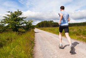 A person runs along a road through countryside