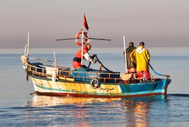 A small fishing boat on a very calm sea