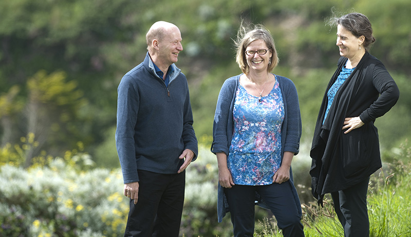 Mike Depledge, Emma Bland and Lora Fleming laugh in a sunny garden