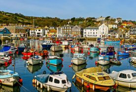 A sunny harbour full of small colourful boats.