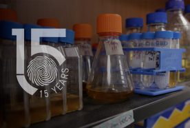 A shelf holds water samples in tubes and bottles with the 15yr logo to the left of the image.